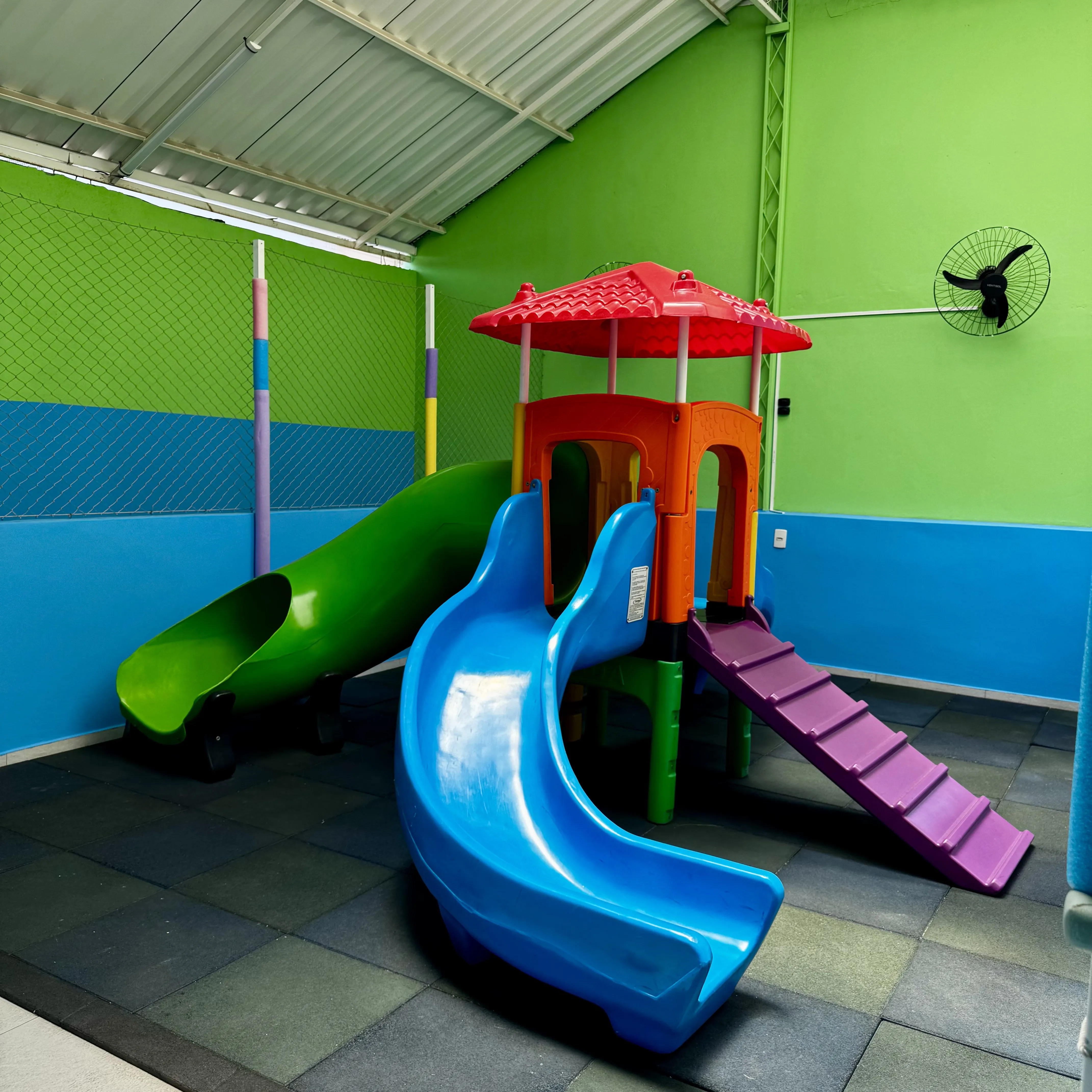 O playground coberto: a torre com telhadinho vermelho e os escorregadores
